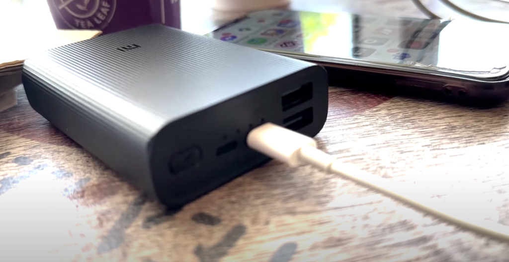 Xiaomi Mi Power Bank 3 placed on a table with a connected charging cable.