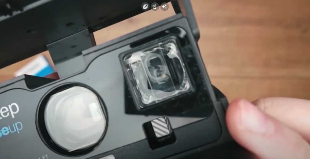 Close-up image of a black Polaroid Sun 660 camera emphasizing its viewfinder function