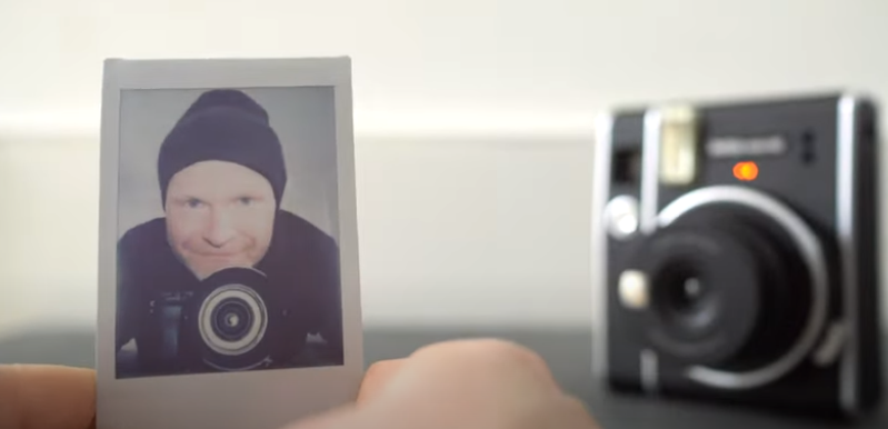 A photo of a man with a camera near the actual camera