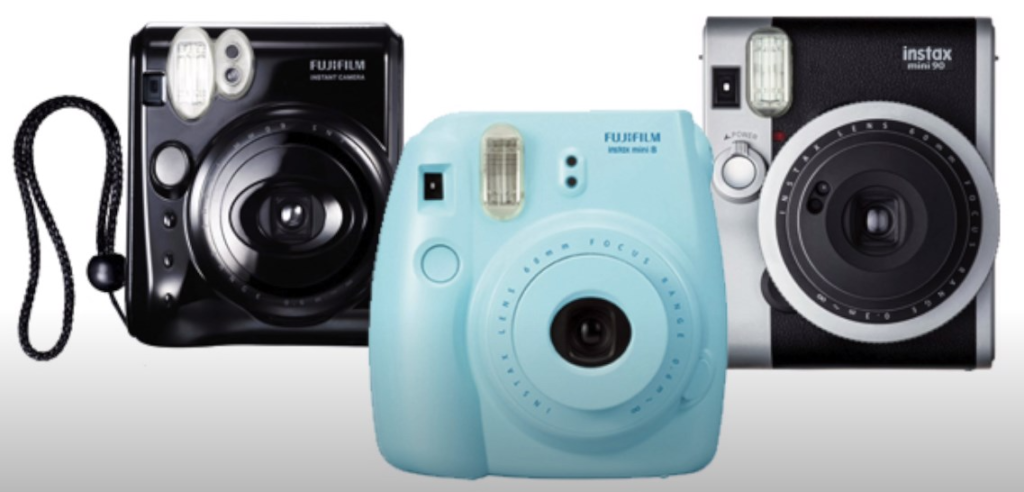 Fujifilm's Instax Mini 8, Instax Mini 9, and Instax Mini 26 cameras on a white background